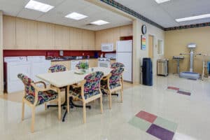 Kitchenette in rehab gym with large table and six chairs
