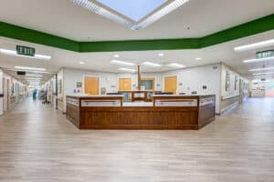 Nurses' desk with two large hallways on either side and wood floors.