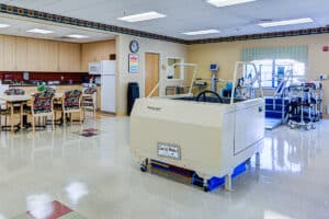 Rehab gym with kitchenette, table and chairs, and physical therapy equipment