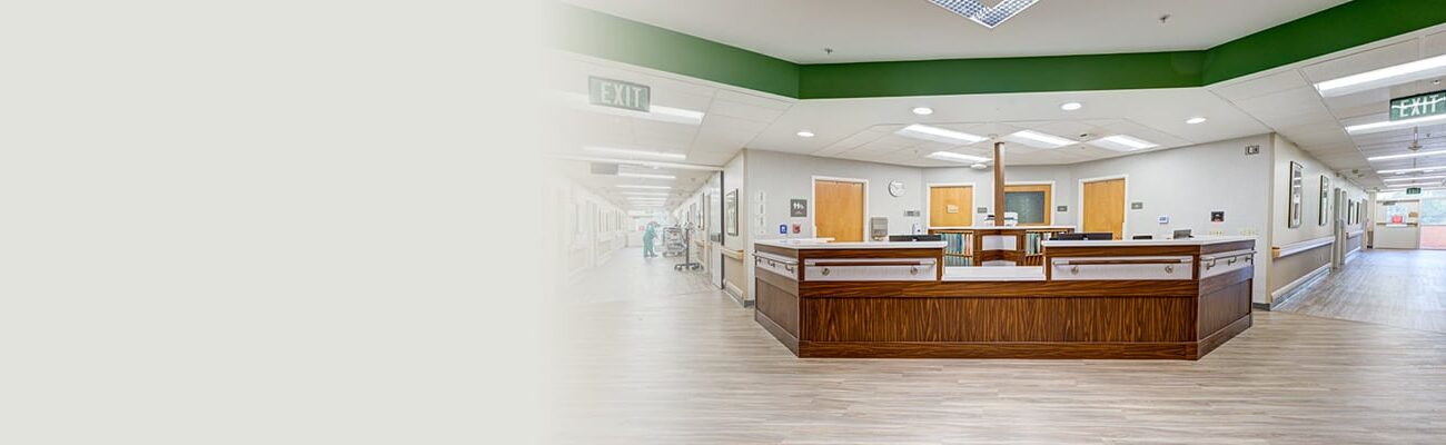 Nurses' station with two large hallways on either side and wood floors.