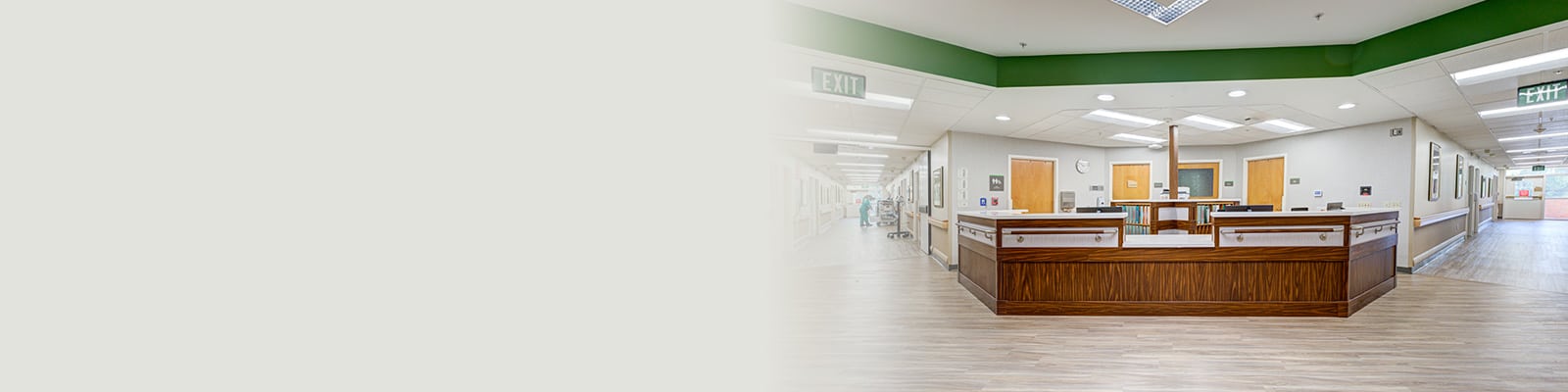 Nurses' station with two large hallways on either side and wood floors.